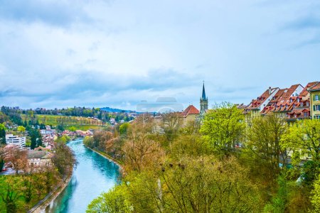 Green banks of Aare river with lush parks and walking promenades in Bern, Switzerland