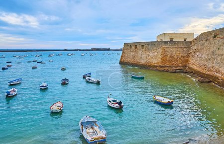 Téléchargez les photos : Les petits bateaux sur la plage de La Caleta contre les châteaux médiévaux de San Sebastian et Santa Catalina, Costa de la Luz, Cadix, Espagne - en image libre de droit