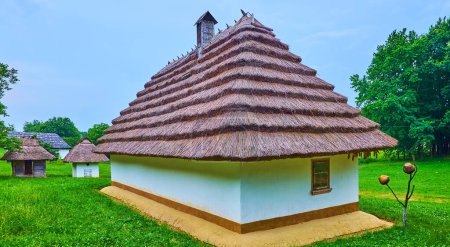 Foto de Panorama de la hermosa casa rural con techo de paja escalonada, rodeado de patio verde, Chernivtsi scansen, Ucrania - Imagen libre de derechos