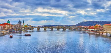 Téléchargez les photos : Panorama de la ville avec la rivière Vltava, bateaux de tourisme flottants et le pont Charles en pierre voûtée médiévale en arrière-plan, Prague, Tchéquie - en image libre de droit