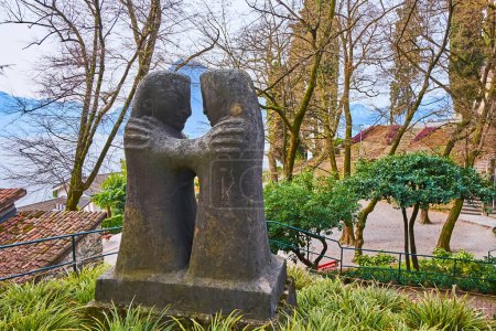 Foto de LUGANO, SUIZA - 16 DE MARZO DE 2023: La escultura de piedra de una pareja abrazada, cubierta de letras y palabras, arañada en piedra, Parco San Michele, Castagnola, Lugano, Suiza - Imagen libre de derechos