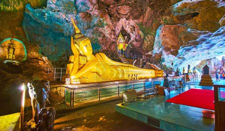 Téléchargez les photos : PHANG NGA, THAÏLANDE - 28 AVRIL : La grotte Tham Yai du temple Wat Suwan Kuha est célèbre pour sa statue d'or ornée de Bouddha couché, le 28 avril à Phang Nga - en image libre de droit