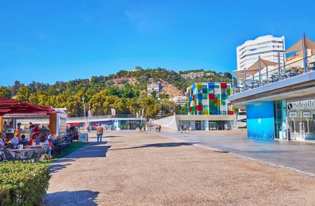 Foto de MALAGA, ESPAÑA - 28 DE SEPTIEMBRE DE 2019: Muelle Uno muelle con tiendas, restaurantes, Centro Pompidou Museo y Castillo Gibralfaro en la cima de la colina en el fondo - Imagen libre de derechos