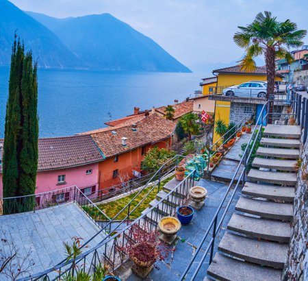 Téléchargez les photos : Panorama de charmantes maisons médiévales avec drapeau de la ville de Lugano, village de montagne Gandria au bord du lac de Lugano, Suisse - en image libre de droit