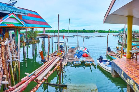 Téléchargez les photos : Le quai de pêche grincheux, fait de vieux bâtons et de planches pourries dans Ko Panyi village flottant, Phang Nga Bay, Thaïlande - en image libre de droit