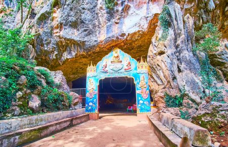 Téléchargez les photos : PHANG NGA, THAÏLANDE - 28 AVRIL : La porte sculptée en couleur devant le temple de la grotte de Wat Suwan Kuha, le 28 avril à Phang Nga - en image libre de droit
