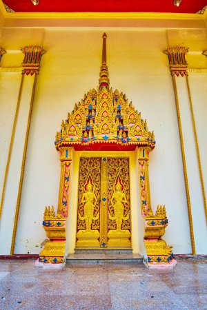 Der turmförmige Türrahmen des Ubosot des Wat Suwan Kuha Tempels und die mit Gottheiten verzierte Tür, Phang Nga, Thailand