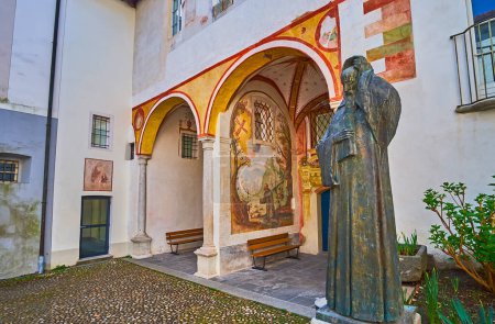 Foto de Estatua de bronce del fraile franciscano Bartolomeo de Ivrea y frescos conservados en el claustro del Santuario de la Virgen del Sasso, Orselina, Suiza - Imagen libre de derechos