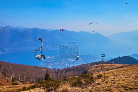 Los nebulosos Alpes Lepontinos, el Lago Mayor, Locarno, el telesilla Cardada Cimetta y la ladera del Monte Cimetta desde su cima, Ticino, Suiza