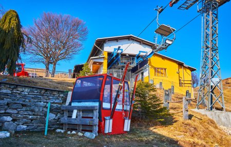 Cabina de góndola de aire rojo vintage frente a la estación superior del telesilla Cardada Cimetta en el Monte Cimetta, Ticino, Suiza