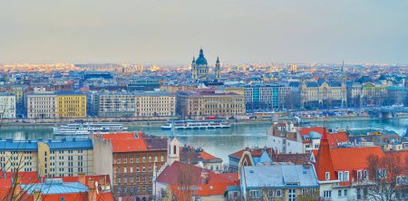 Panorama der roten Ziegeldächer von Buda, Donau mit Touristenschiffen und der Pester Skyline mit der St.-Stephans-Basilika, Budapest, Ungarn