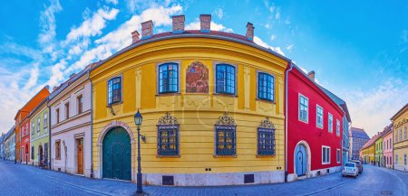 Panorama of historic narrow curved Tancsics Mihaly Street with line of small colored houses, Buda Castle Quarter, Budapest, Hungary
