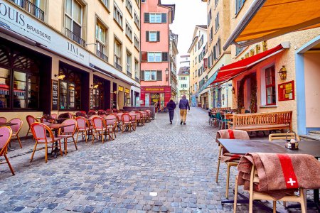 Téléchargez les photos : ZURICH, SUISSE - 3 AVRIL 2022 : Rue Niederdorfstrasse avec une myriade de charmants cafés et restaurants avec des places assises en plein air, le 3 avril à Zurich, Suisse - en image libre de droit