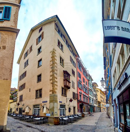 Foto de ZURICH, SUIZA - 3 DE ABRIL DE 2022: Panorama de las calles medievales Brunn-Gasse y Froschau-Gasse con casas altas en el corazón del casco antiguo, el 3 de abril en Zurich, Suiza - Imagen libre de derechos