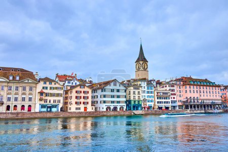 Limmat River presenta encanto medieval, con el campanario de Peterskirche realzando el panorama atemporal, Zurich, Suiza