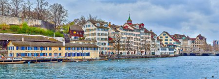 Foto de ZURICH, SUIZA - 3 DE ABRIL DE 2022: Las residencias frente al río del distrito de Schipfe en Zurich ofrecen un entorno encantador y pintoresco a lo largo del río Limmat, el 3 de abril en Zurich, Suiza - Imagen libre de derechos