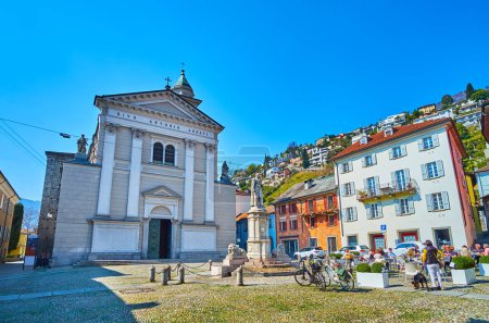Historic Piazza Sant'Antonio with outdoor dinings, monument to Giovanni Antonio Marcacci and St Anthony Church, Locarno, Ticino, Switzerland