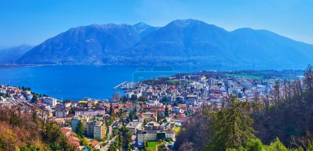 Panorama of the old town and residential quarters of Locarno, blue Lake Maggiore and mountain range behind it, Ticino, Switzerland