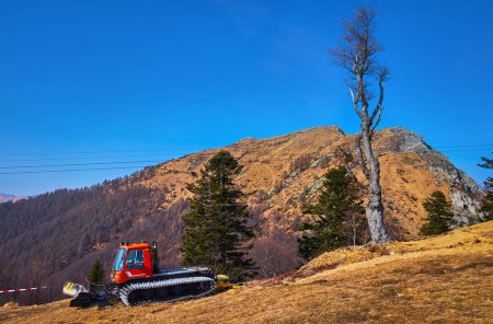 Téléchargez les photos : La dameuse à neige contre le pré montagneux asséché de Cima Madone, vue depuis le mont Cardada Cimetta, Tessin, Suisse - en image libre de droit