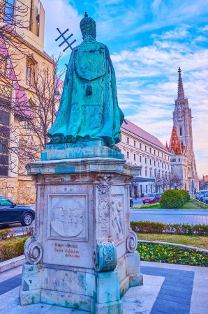 El monumento de bronce del Papa Inocencio XI en la Plaza Hess Andras contra el campanario gótico de la Iglesia de Matías, Budapest, Hungría