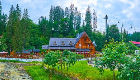 Téléchargez les photos : Le restaurant pittoresque en bois derrière l'étroit ruisseau de montagne à Bukovel Carpthian resort, Ukraine - en image libre de droit