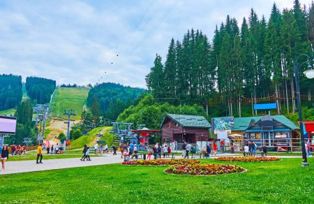 Photo for BUKOVEL, UKRAINE - JULY 25, 2021: The scenic green pedestrian zone in front of the chairlift, connecting resort with Mount Bukovel, on July 25 in Bukovel - Royalty Free Image