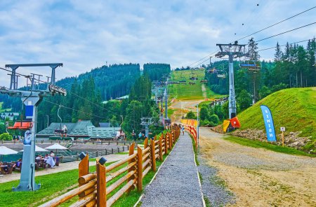 Photo for The mountain carting track runs on the slope of Mount Bukovel, next to the chair lifts, Carpathians, Ukraine - Royalty Free Image