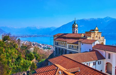 The red tile roof of Madonna del Sasso Sanctuary and the bell tower of Santa Maria Assunta Church against the Lake Maggiore and mountains, Orselina, Switzerland