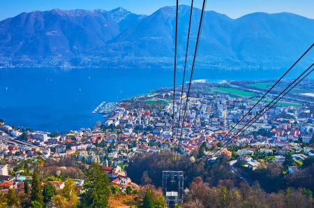 The breathtaking Cardada Cimetta cable car ride over the roofs of Locarno, Lake Maggiore and hazy Alps, Switzerland