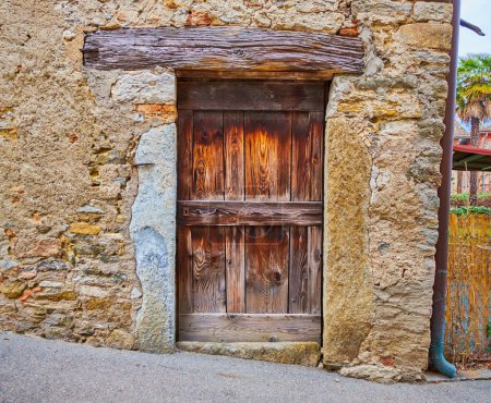 Antigua puerta de madera y pared de mala calidad de la casa histórica en Savosa pueblo, Suiza