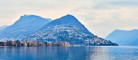 Lac de Lugano avec des maisons au bord du lac de la ville de Lugano et une vue sur Monte Bre et Monte Boglia sur fond, Suisse