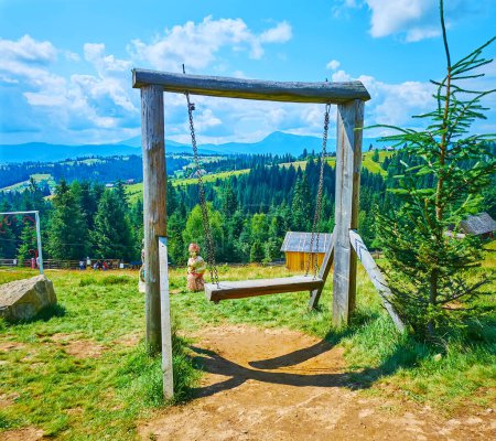 The log swing in Mountain Valley Peppers (Polonyna Pertsi) against the scenic green mountain landscape, Carpathians, Ukraine