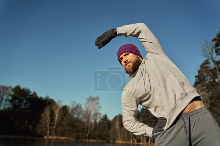 Photo for Adult caucasian man warming up before winter swimming - Royalty Free Image