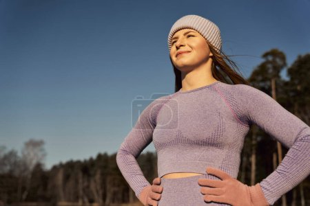 Téléchargez les photos : Femme caucasienne prendre une respiration et attraper des rayons de soleil à l'extérieur en hiver - en image libre de droit