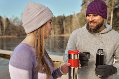 Téléchargez les photos : Couple caucasien boire du thé chaud en hiver debout à l'extérieur - en image libre de droit