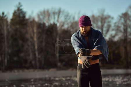 Photo for Caucasian adult man go out of frozen lake in the winter - Royalty Free Image