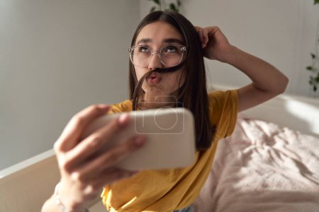 Photo for Caucasian teenage girl making funny face while taking selfie - Royalty Free Image