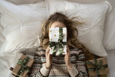 Top view caucasian woman covering face with a Christmas gift 