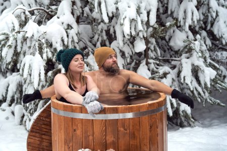 Photo for Caucasian couple during the winter bath in tube outdoors - Royalty Free Image