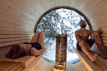Téléchargez les photos : Caucasian adult couple enjoying in the sauna in winter - en image libre de droit