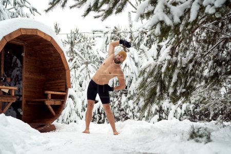 Photo for Caucasian man warming up before winter swim in barrel - Royalty Free Image
