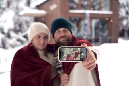 Foto de Caucásico pareja haciendo selfie en frente de casa en invierno temporada - Imagen libre de derechos