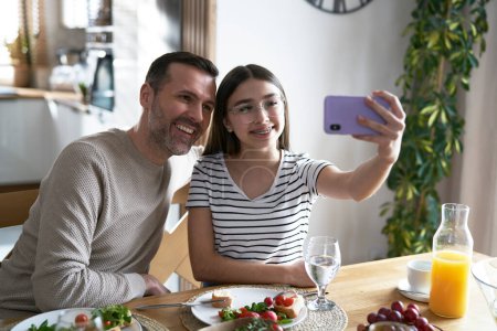 Photo for Teenager girl make a selfie with dad at home - Royalty Free Image