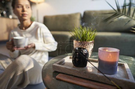 Photo for Woman in background at home with incense - Royalty Free Image