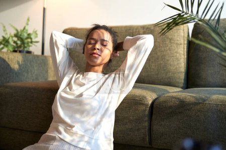 Téléchargez les photos : Mixed race woman sitting at home and enjoying the sunrise - en image libre de droit