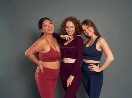 Portrait de trois jeunes femmes en vêtements de sport en studio tourné