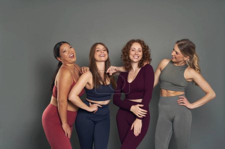 Téléchargez les photos : Group of four young women in sports clothes in studio shot - en image libre de droit