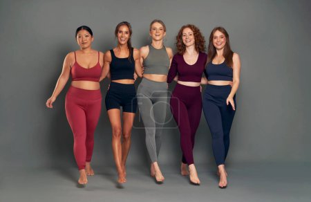 Téléchargez les photos : Portrait de cinq femmes en vêtements de sport marchant vers la caméra en studio tourné - en image libre de droit