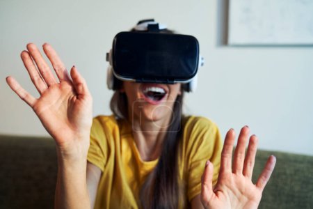 Foto de Woman in Virtual Reality glasses having fun at home - Imagen libre de derechos