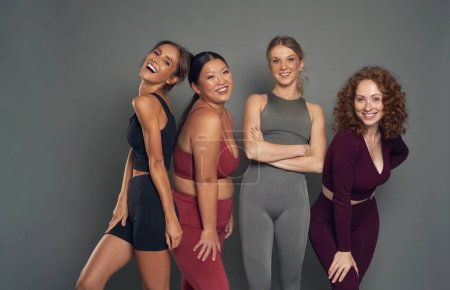 Téléchargez les photos : Quatre jeunes femmes confiantes en vêtements de sport en studio tourné - en image libre de droit